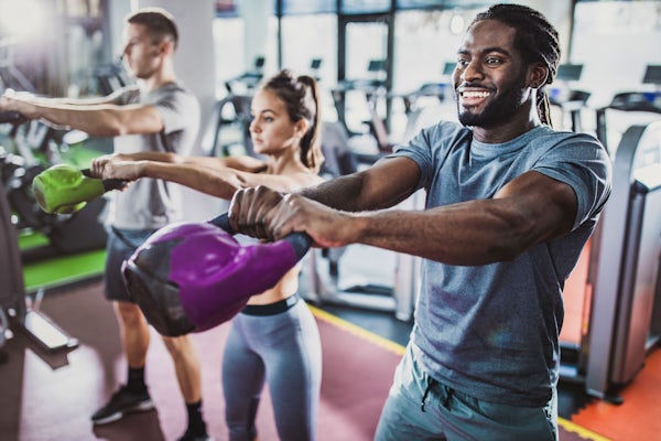 Group of athletes exercising with kettle bells on 