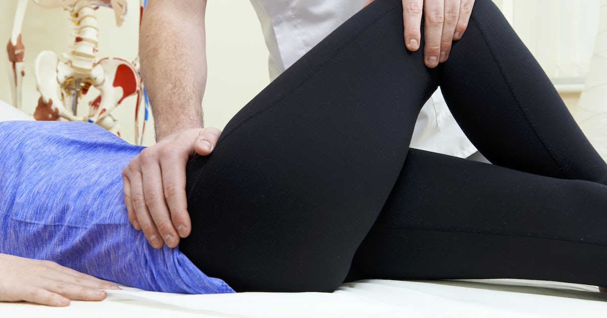 Male Osteopath Treating Female Patient With Hip Pr